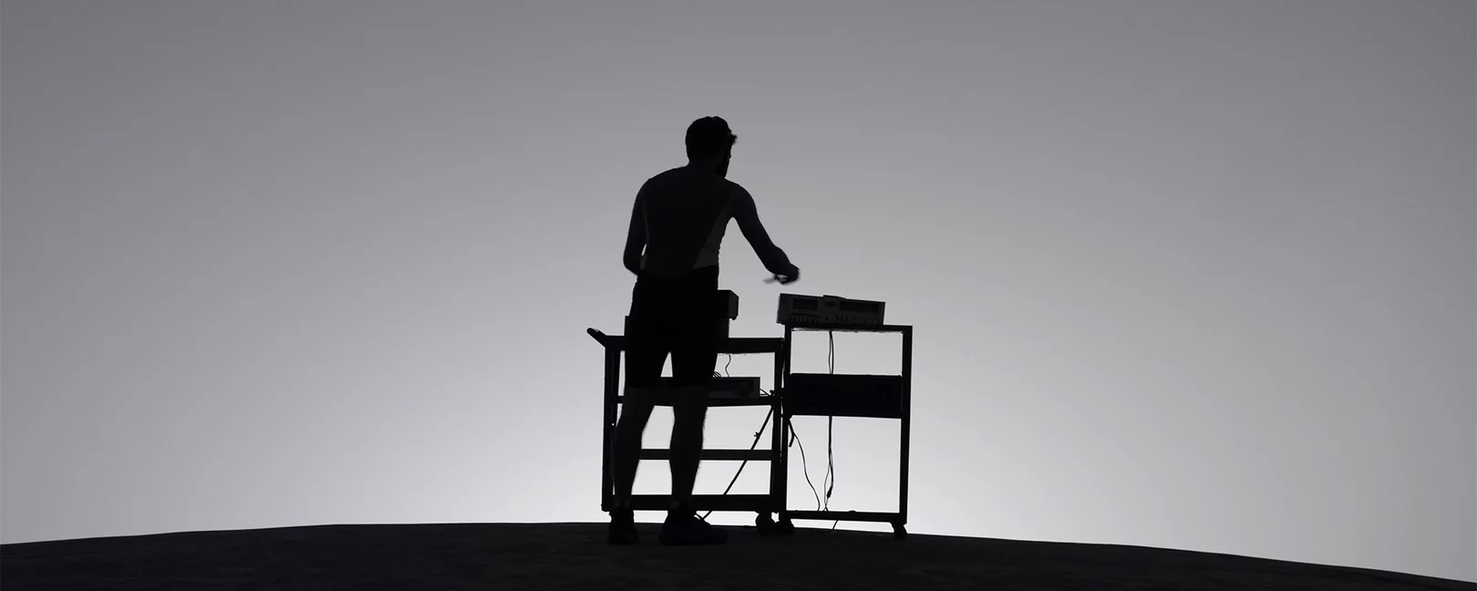 Silhouette of a man playing an electronic music device 