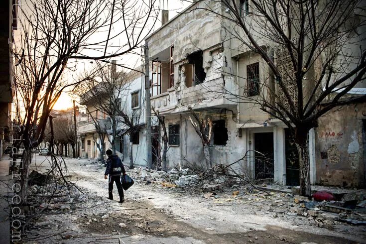A boy walking in a street in Bab Amr, Homs. Daniels and 3 other journalists were holed up for days is behind the building at right