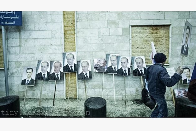 Photos of Assad and Russia's Putin are seen during a pro-Assad protest in front of the Russian embassy in Damascus, Syria